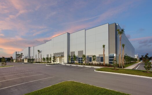 Large, modern warehouse building with tall windows and palm trees at 8515 126th Ave N in Largo, FL, surrounded by an empty parking lot at sunset. Currently leased.