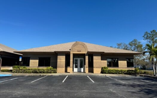 Single-story brick office building on Park Street with large windows, double glass doors, and an empty parking lot under a clear blue St. Petersburg sky—now available to be leased.