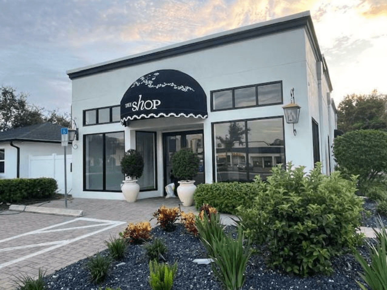 A small storefront with large windows, a black awning labeled "the shop," decorative plants, and a landscaped front area at 3440 4th St. N., St. Petersburg, FL 33704—recently sold in this vibrant neighborhood.