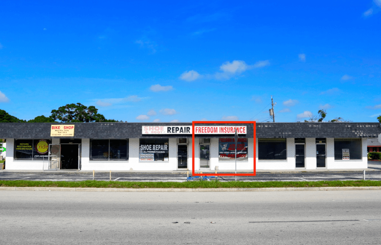 A single-story strip mall on 49th St. in St. Petersburg features several storefronts, including "Freedom Insurance" outlined in red, a shoe repair shop, and a bike shop—some spaces currently leased.