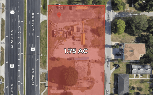Aerial view of a 1.75-acre lot outlined in red at the corner of US Hwy 19 N and Count Dr in New Port Richey, FL, with surrounding streets and buildings visible.